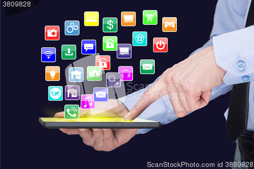 Image of Businessman holding a tablet pc with mobile applications icons on virtual screen . Internet and business concept.