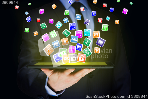 Image of Businessman holding a tablet pc with mobile applications icons on virtual screen . Internet and business concept.