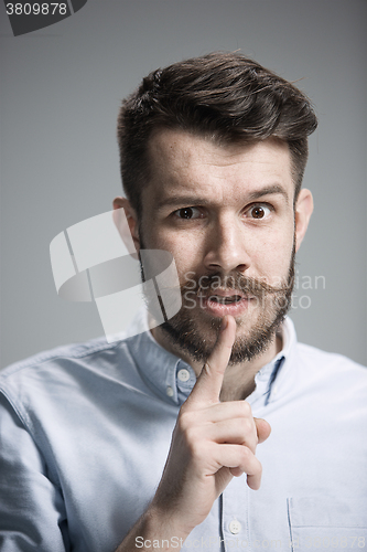 Image of Man is looking wary. Over gray background