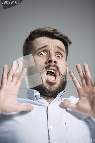 Image of Man is looking scared. Over gray background