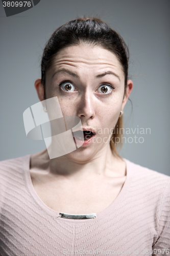 Image of Portrait of young woman with shocked facial expression