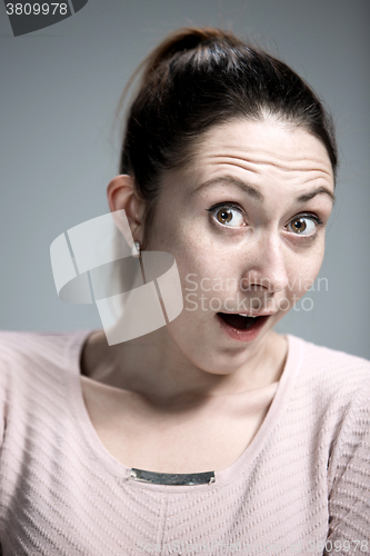 Image of Portrait of young woman with shocked facial expression