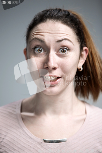 Image of Portrait of young woman with shocked facial expression