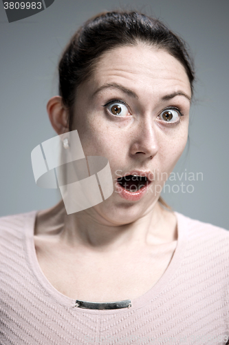 Image of Portrait of young woman with shocked facial expression