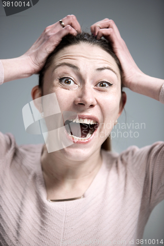 Image of Portrait of young woman with shocked facial expression