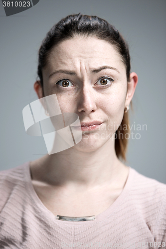 Image of Woman is looking imploring over gray background