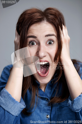 Image of Portrait of young woman with shocked facial expression