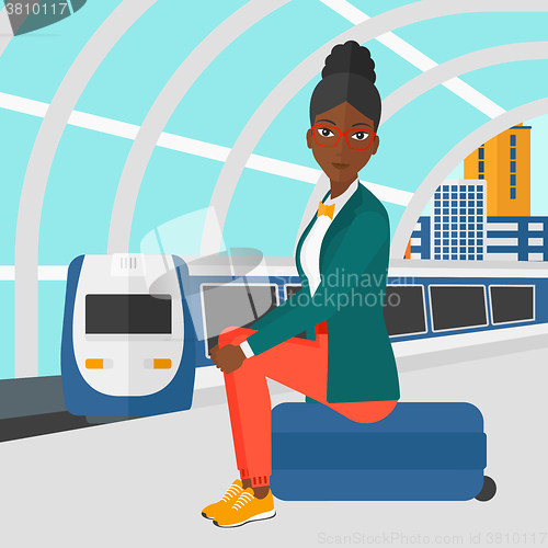 Image of Woman sitting on railway platform.