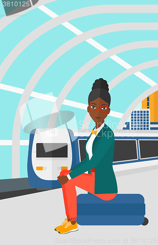 Image of Woman sitting on railway platform.