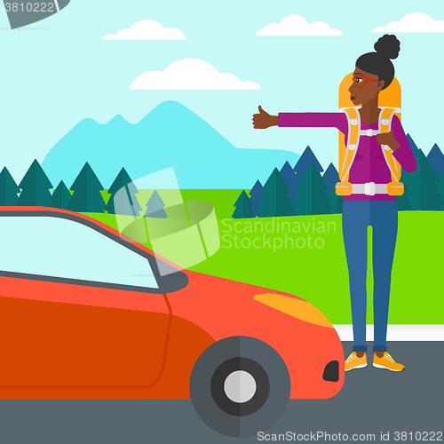 Image of Young woman hitchhiking.