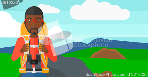 Image of Cheerful backpacker with binoculars.