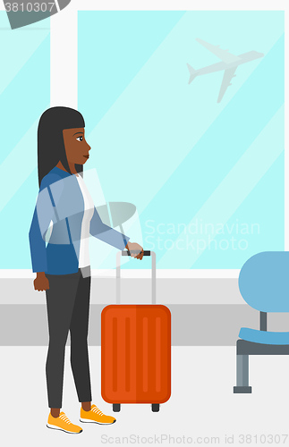 Image of Woman at airport with suitcase.