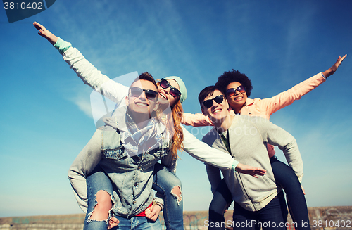 Image of happy friends in shades having fun outdoors