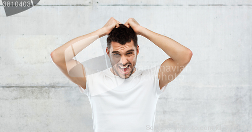 Image of crazy shouting man in t-shirt over gray background