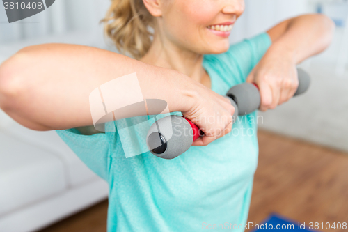 Image of close up of woman exercising with dumbbell at home