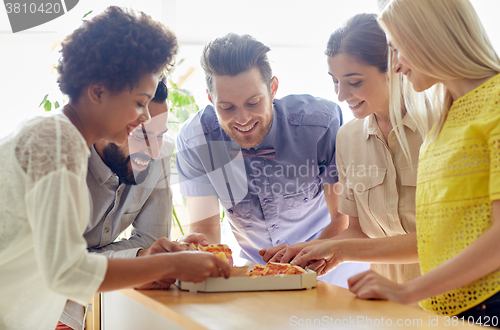 Image of happy business team eating pizza in office