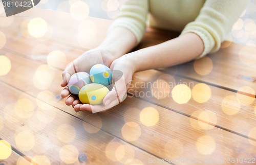 Image of close up of woman hands with colored easter eggs