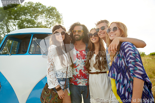 Image of smiling young hippie friends over minivan car