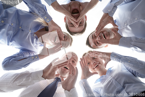 Image of smiling group of businesspeople standing in circle