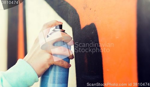 Image of close up of hand drawing graffiti with spray paint