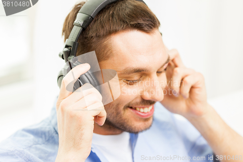 Image of smiling young man in headphones at home