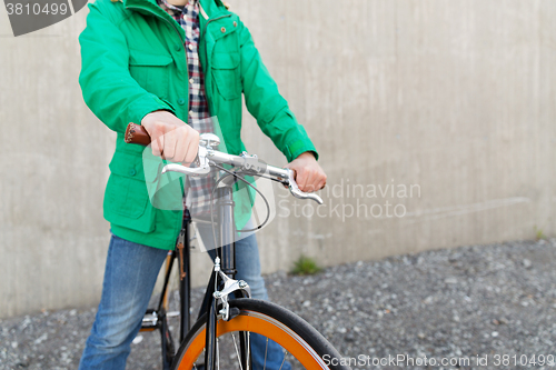Image of close up of man with fixed gear bike on street