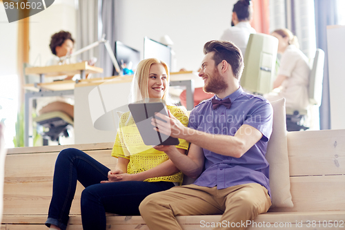 Image of happy creative team with tablet pc in office