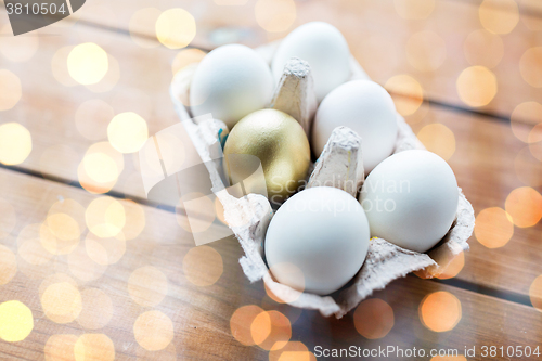 Image of close up of white and gold eggs in egg box