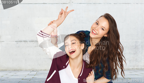 Image of happy pretty teenage girls showing peace hand sign