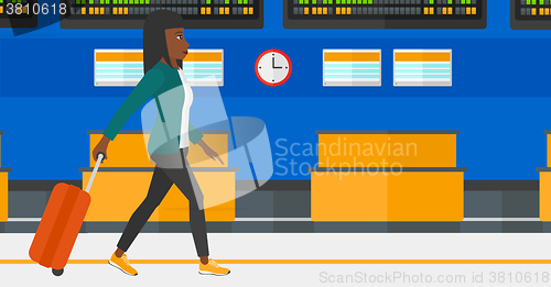 Image of Woman walking with suitcase.