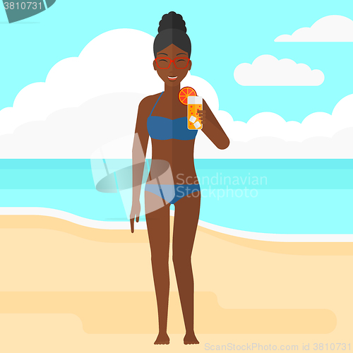 Image of Tourist with cocktail on the beach.