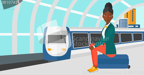 Image of Woman sitting on railway platform.