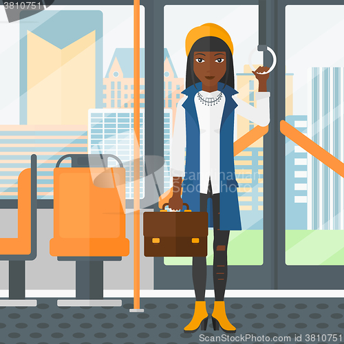 Image of Woman standing inside public transport.