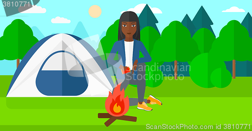 Image of Woman kindling fire.