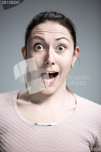 Image of Portrait of young woman with shocked facial expression