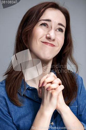Image of Woman is looking imploring over gray background