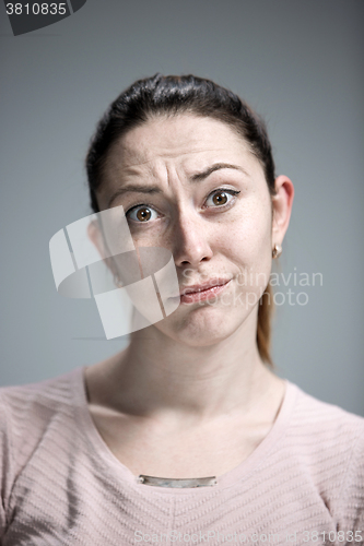 Image of Woman is looking imploring over gray background