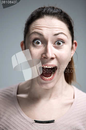 Image of Portrait of young woman with shocked facial expression