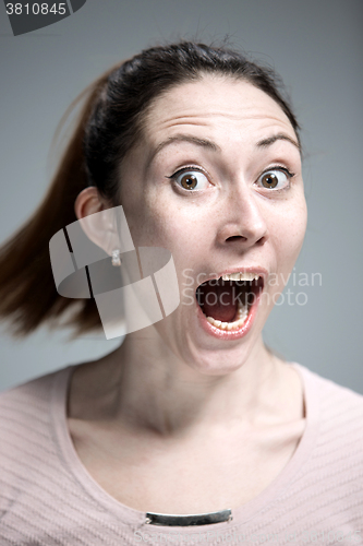 Image of Portrait of young woman with shocked facial expression