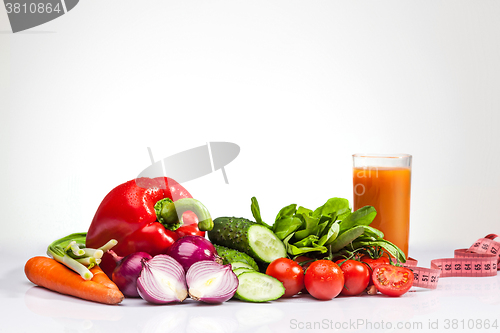 Image of The tape measure with tomatoes and vegetables on white