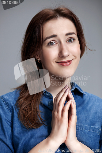Image of Woman is looking imploring over gray background