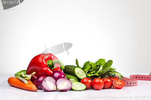 Image of The tape measure with tomatoes and vegetables on white