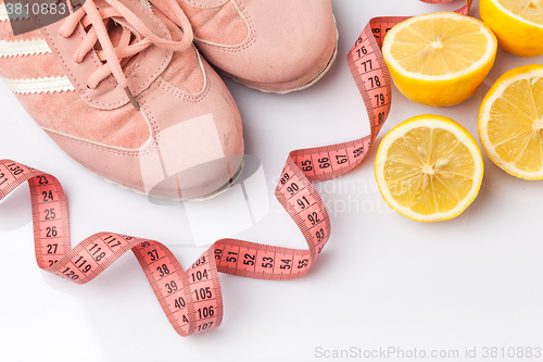 Image of The old sneakers, a meter tape and lemon on an white