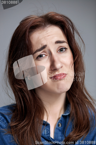 Image of Woman is looking imploring over gray background