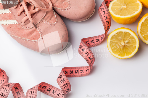 Image of The old sneakers, a meter tape and lemon on an white