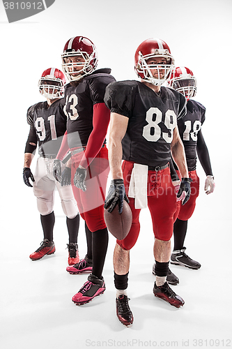 Image of The four american football players posing with ball on white background