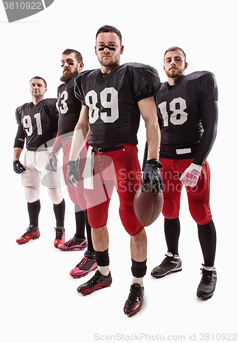 Image of The four american football players posing with ball on white background