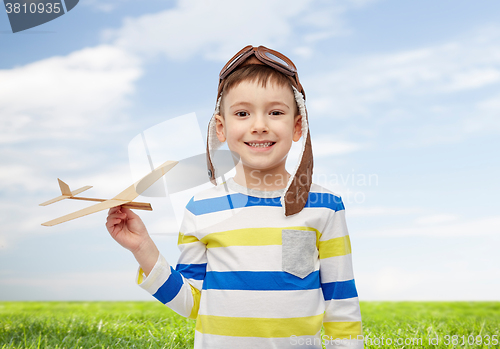 Image of happy little boy in aviator hat with airplane