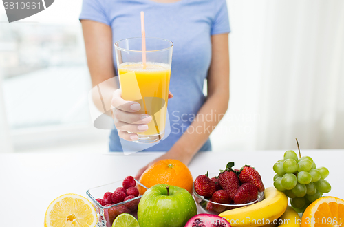 Image of close up of woman holding orange juice with fruits