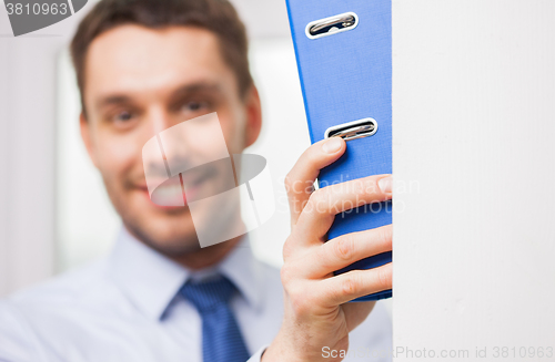 Image of close up of businessman with ring binder in office